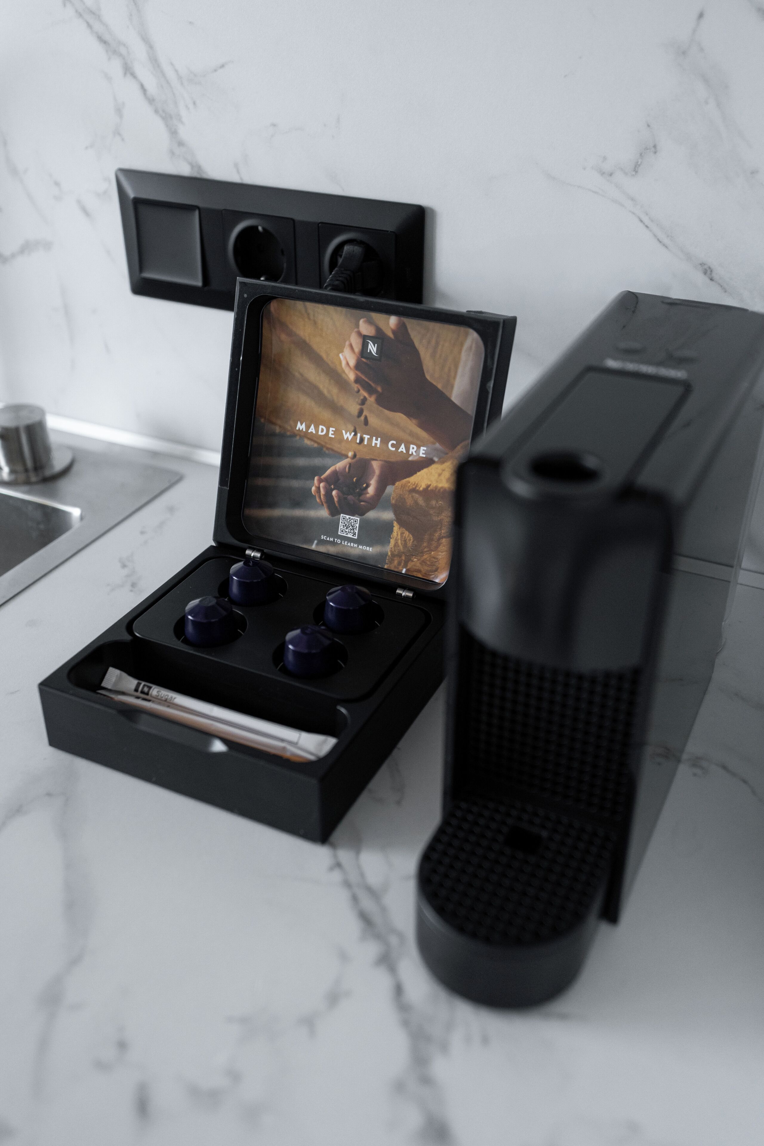 A coffee machine with a digital display, a coffee grinder, and a water reservoir on a marble countertop.
