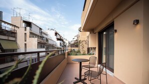 Ein Balkon mit Tisch und Stühlen, mit Blick auf eine Wohngegend mit mehreren Gebäuden.