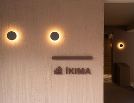 Una pared con dos luces circulares y un letrero que dice "IKIMA".