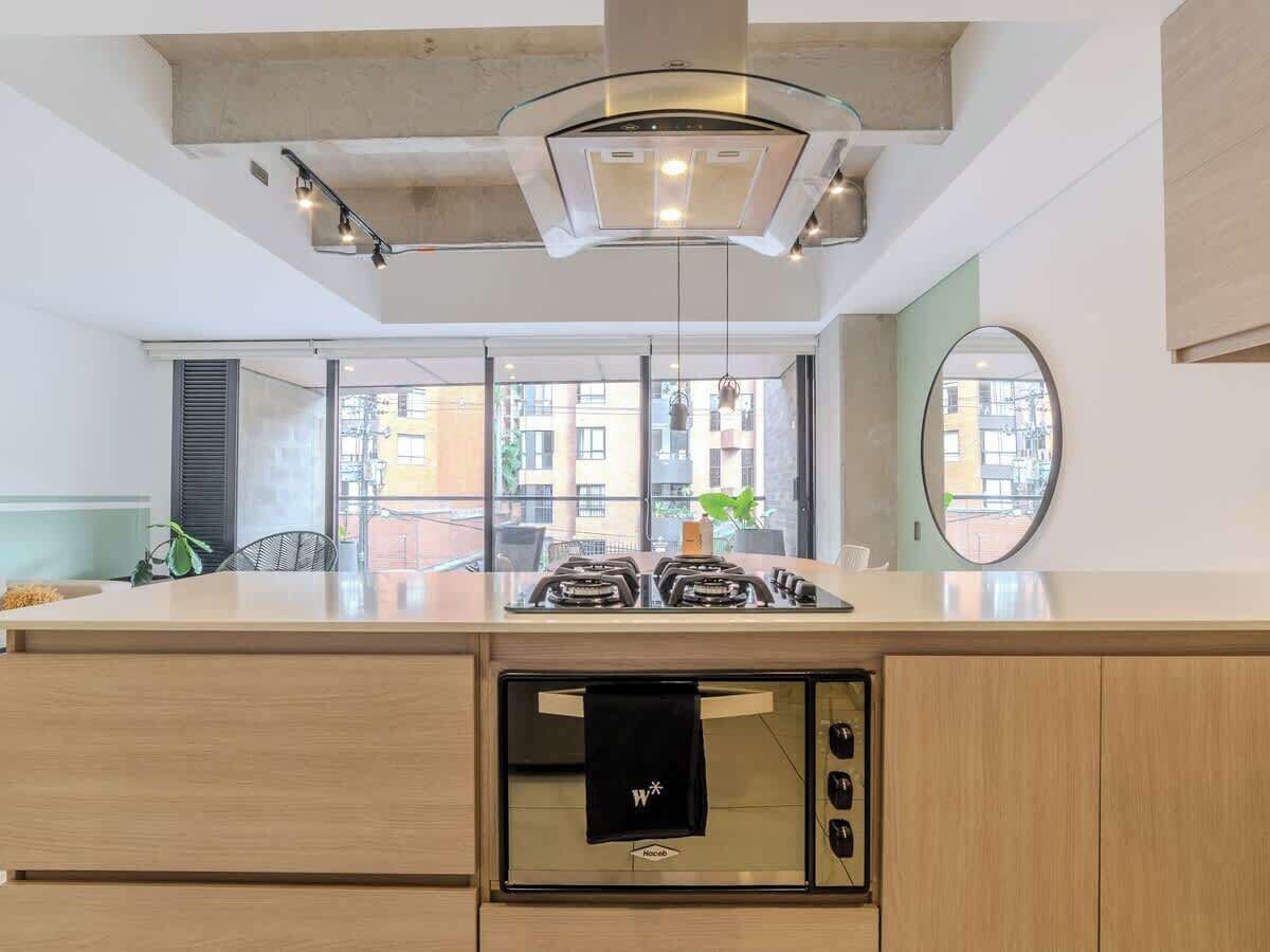 A modern kitchen with a gas stove, oven, and a hanging towel.