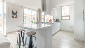A modern kitchen with a large island, bar stools, and a stainless steel range hood. - Modern Apartment in Usaquien (Bogotá)
