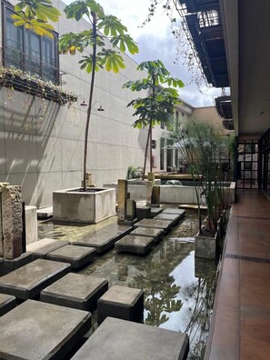 A courtyard with a water feature, stone steps, and potted plants. - Amazing Studio in Candelaria - La Primera 206 (Bogotá)