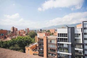 A cityscape with modern buildings, including a multi-story structure with balconies and a flat-roofed building with a flat facade.