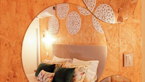 A bedroom with a bed, pillows, a bedside table, and a mirror reflecting the room. - House in the Gerês area (4840-070)