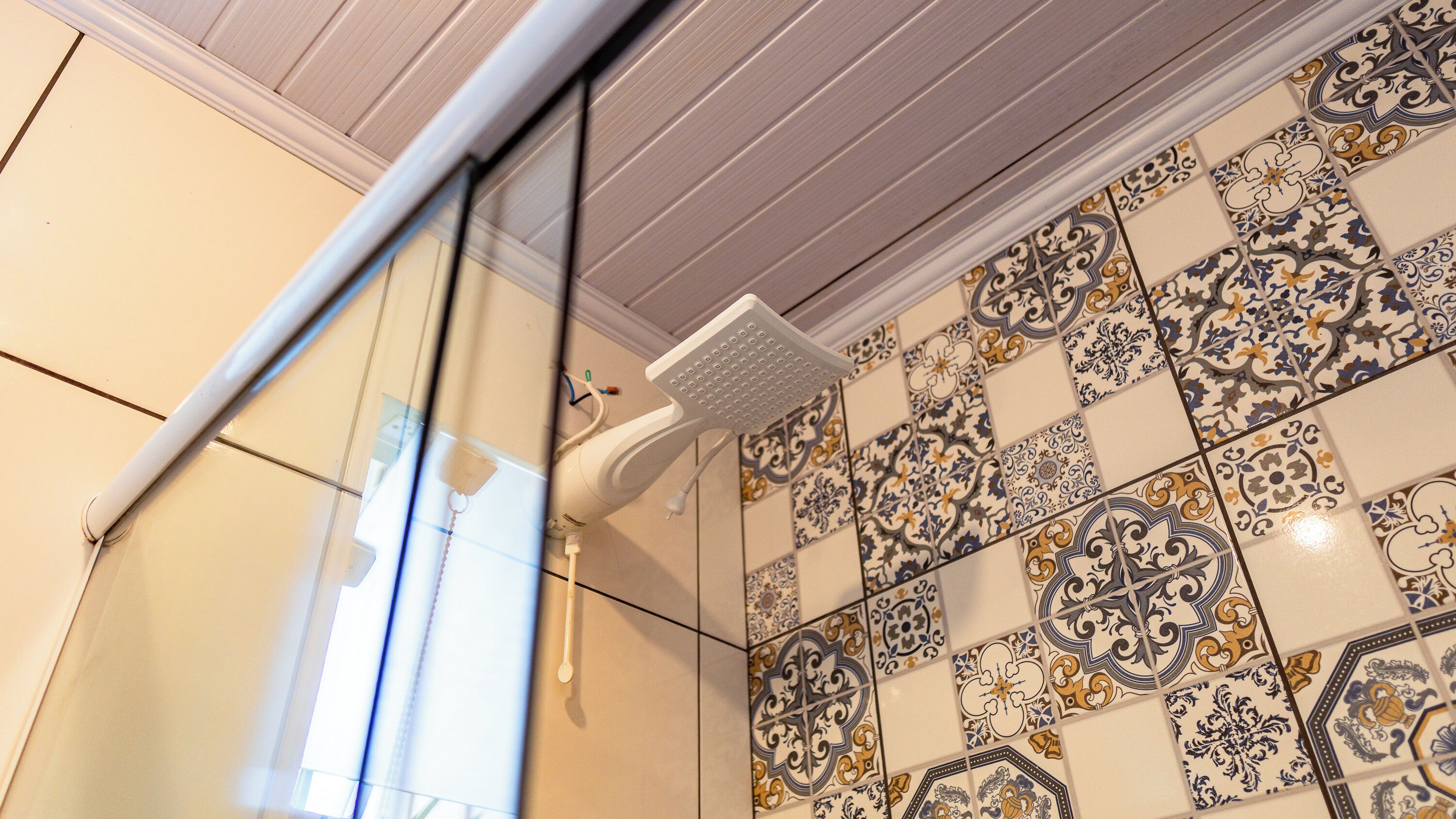 A bathroom with a shower, tiled walls, and a window.