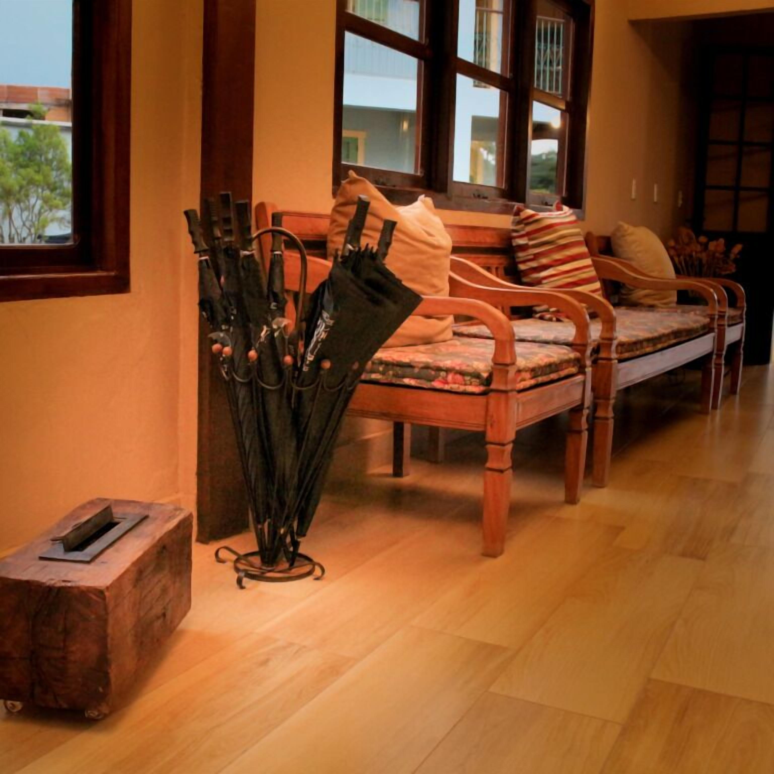 A wooden bench with a cushion and a small table with an umbrella stand.