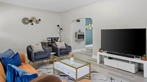 Una sala de estar moderna con dos sillones, una mesa de centro, un televisor y una chimenea.