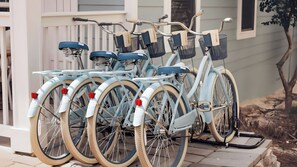 Une rangée de vélos est garée devant une maison dotée d’un porche.