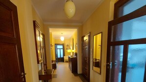 A hallway with wooden doors, a carpeted floor, and a ceiling light.