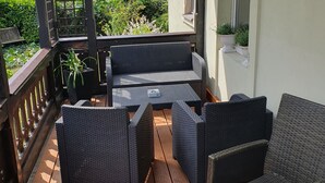 A wooden deck with wicker furniture and a pergola.