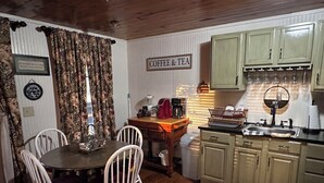 A cozy kitchen with a dining table, chairs, and a coffee station. - Charming 1-bedroom farm guesthouse in Lexington with WiFi and AC (Lexington)