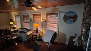 A cozy living room with a ceiling fan, plaid sofas, a coffee table with a chessboard, and a lamp. - Charming 1-bedroom farm guesthouse in Lexington with WiFi and AC (Lexington)