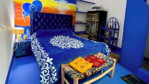 A bedroom with a bed, a night sky mural, a wooden bench, and a wardrobe. - Don't miss this unique blue planet. (Asilah)