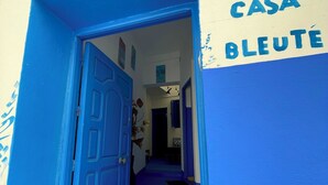 A hallway with a blue door leading to a room labeled 'CASA BLEUTE'. - Don't miss this unique blue planet. (Asilah)