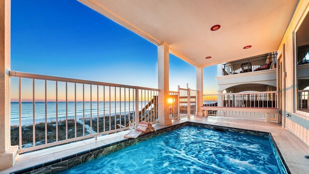 Una piscina con vista al océano, un balcón con barandilla y un interior bañado por el sol.