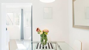 A modern interior with a glass table, a vase of flowers, and a minimalist design. - Gorgeous home in Mravince (Mravince)