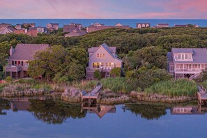 A coastal property with a large house, dock, and surrounding forest. - Mucky Duck | Soundfront Cottage with Private Pier (Kitty Hawk)