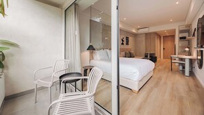 A modern hotel room with a large bed, a small desk, a chair, and a potted plant. - Quadrato | Laureles Studio, w/AC, Balcony, WIFI (Medellín)
