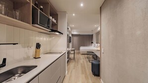 A modern kitchen with a built-in microwave, a sink, and a knife block. - Quadrato | Laureles Studio, w/AC, Balcony, WIFI (Medellín)