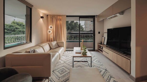 Ein modernes Wohnzimmer mit einer Couch, einem Couchtisch und einem Fernseher.