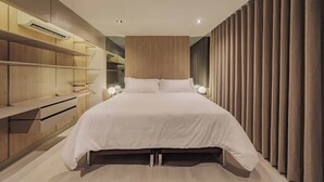 Ein modernes Schlafzimmer mit einem großen Bett, Einbauschränken und einer Wandverkleidung.