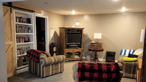 Ein gemütliches Wohnzimmer mit Kamin, Bücherregal und Fernseher.
