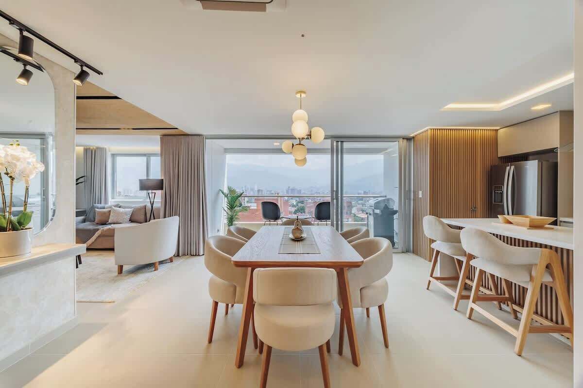 Un salon moderne avec un coin repas, de grandes fenêtres et une vue sur la ville.