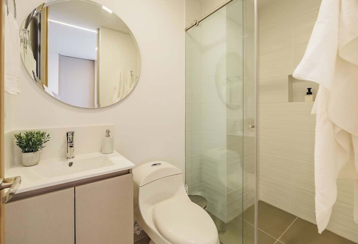 A modern bathroom with a toilet, sink, and shower.