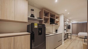A modern kitchen with wooden cabinets, a black refrigerator, and a built-in microwave.