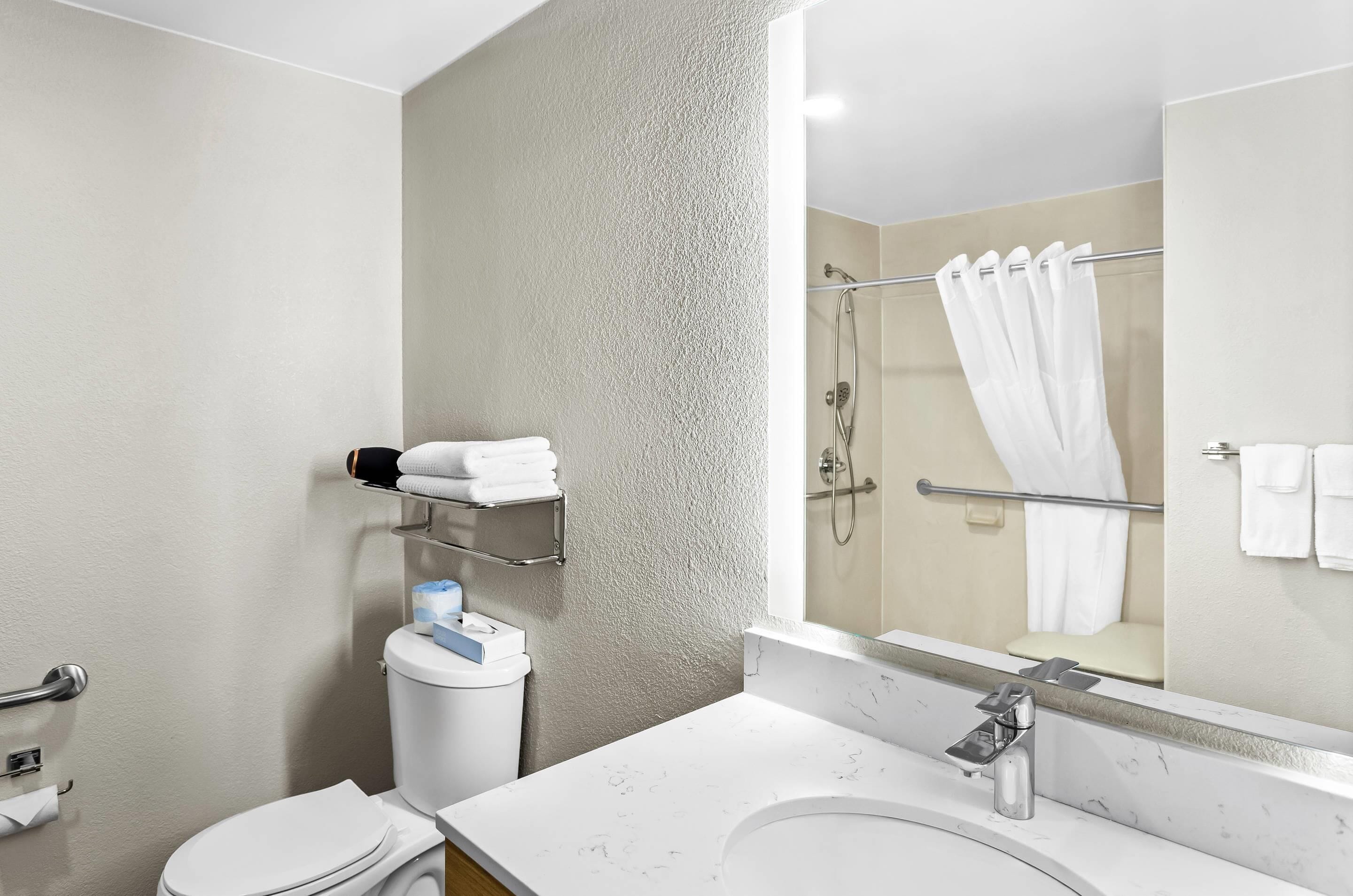 A modern bathroom with a toilet, sink, and shower area.