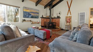 Una sala de estar acogedora con chimenea, vigas de madera y asientos cómodos.