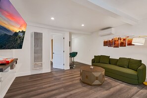 Ein modernes Wohnzimmer mit einem grünen Sofa, einem Couchtisch und einer Wandlampe.