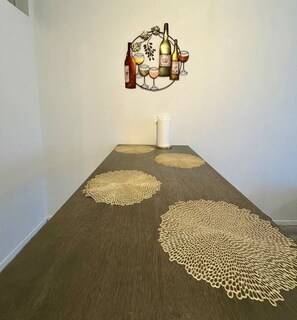 Simple, elegant space with a long table, artwork, and a vase.