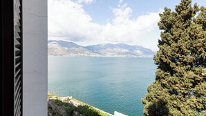 Une vue sur la côte, avec un ciel dégagé, une étendue d’eau et des montagnes à l’horizon.