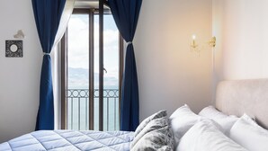 Un dormitorio con cama, vista al mar y balcón.