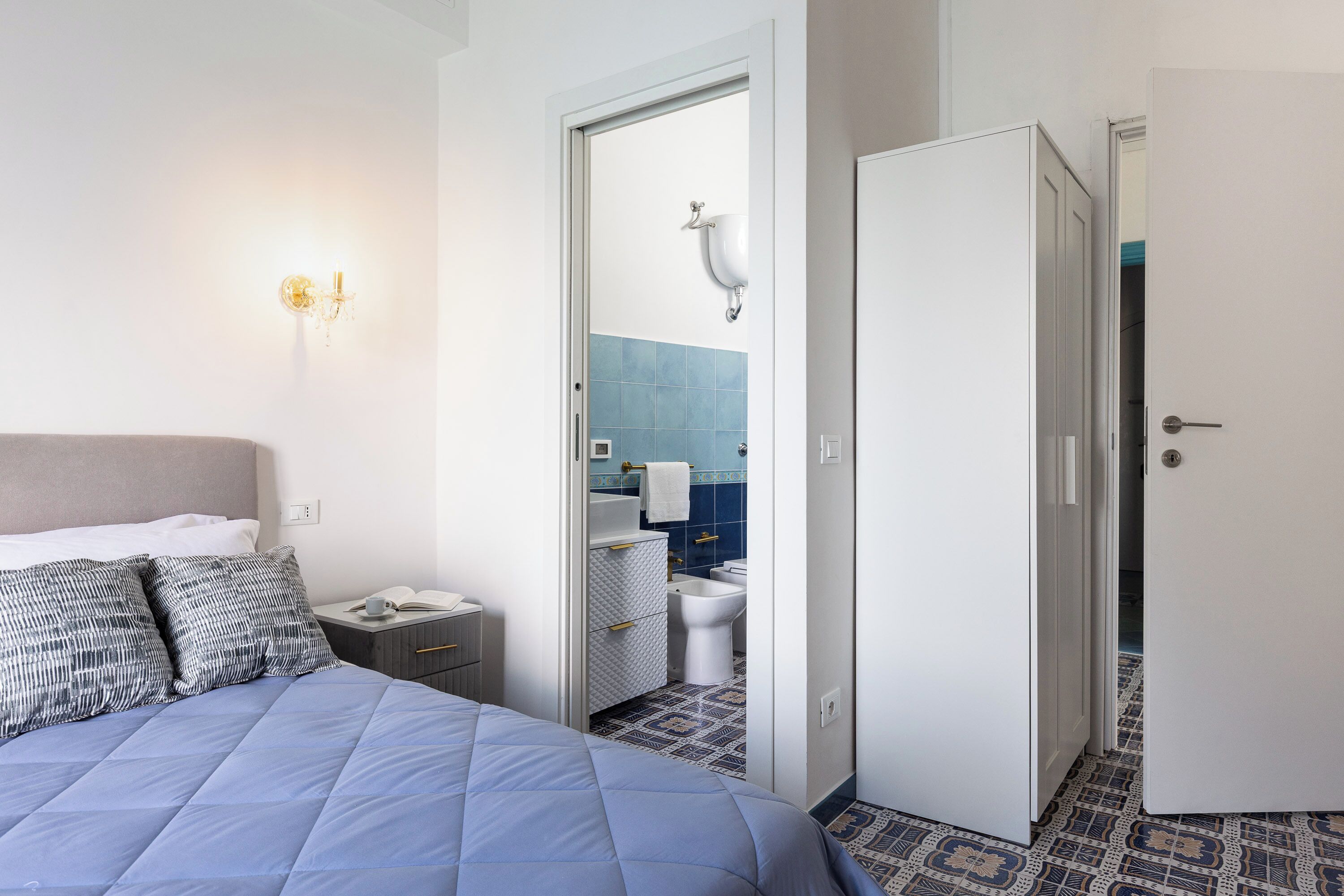 Ein Hotelzimmer mit Bett, Nachttisch, offenem Badezimmer und Kleiderschrank.