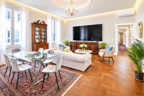 A modern living room with a glass dining table, white sofa, and a flat-screen TV. - THE BEST FOR YOUR VACATION!!! LUXURY APARTMENT for 7!!! ST. PETER'S BASILICA, VATICAN CITY (Roma)