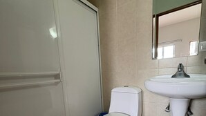 A bathroom with a toilet, sink, and a mirror. - Bugambilias Hotel Hacienda (Durango)