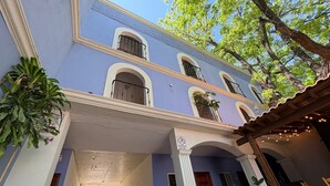 A two-story building with a blue facade, white trim, and multiple balconies. - Bugambilias Hotel Hacienda (Durango)