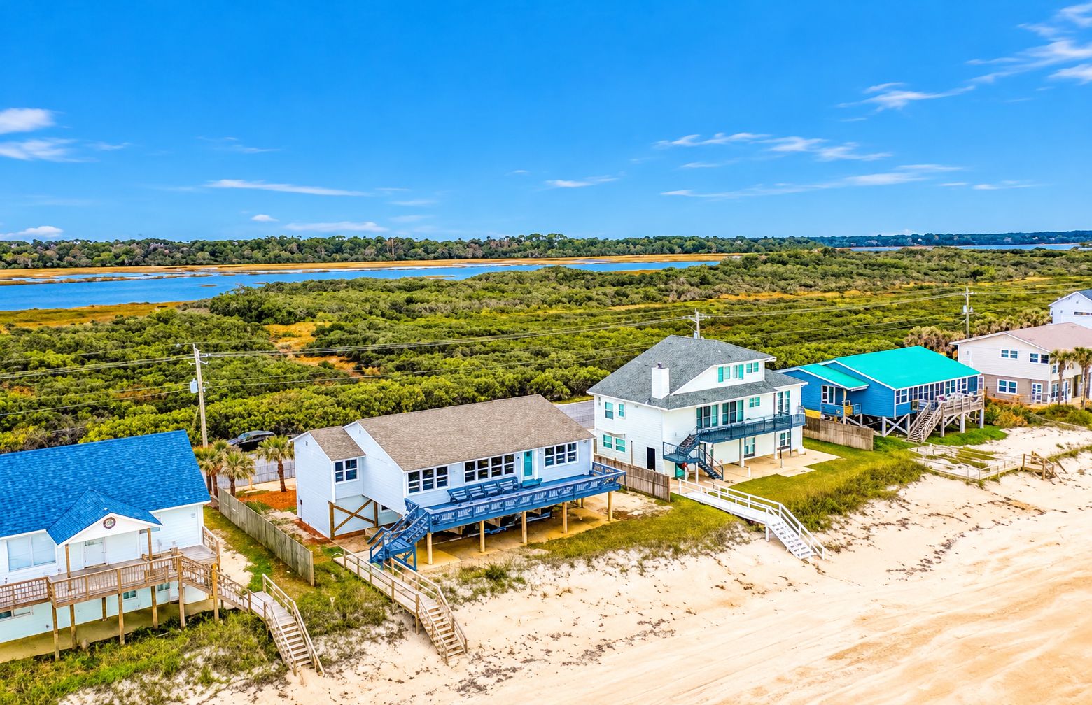 A coastal property with multiple buildings, including a house with a blue roof and a larger structure with a blue exterior.
