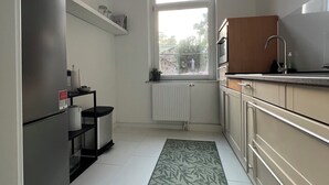 Una cocina moderna con refrigerador, microondas y armarios de madera.