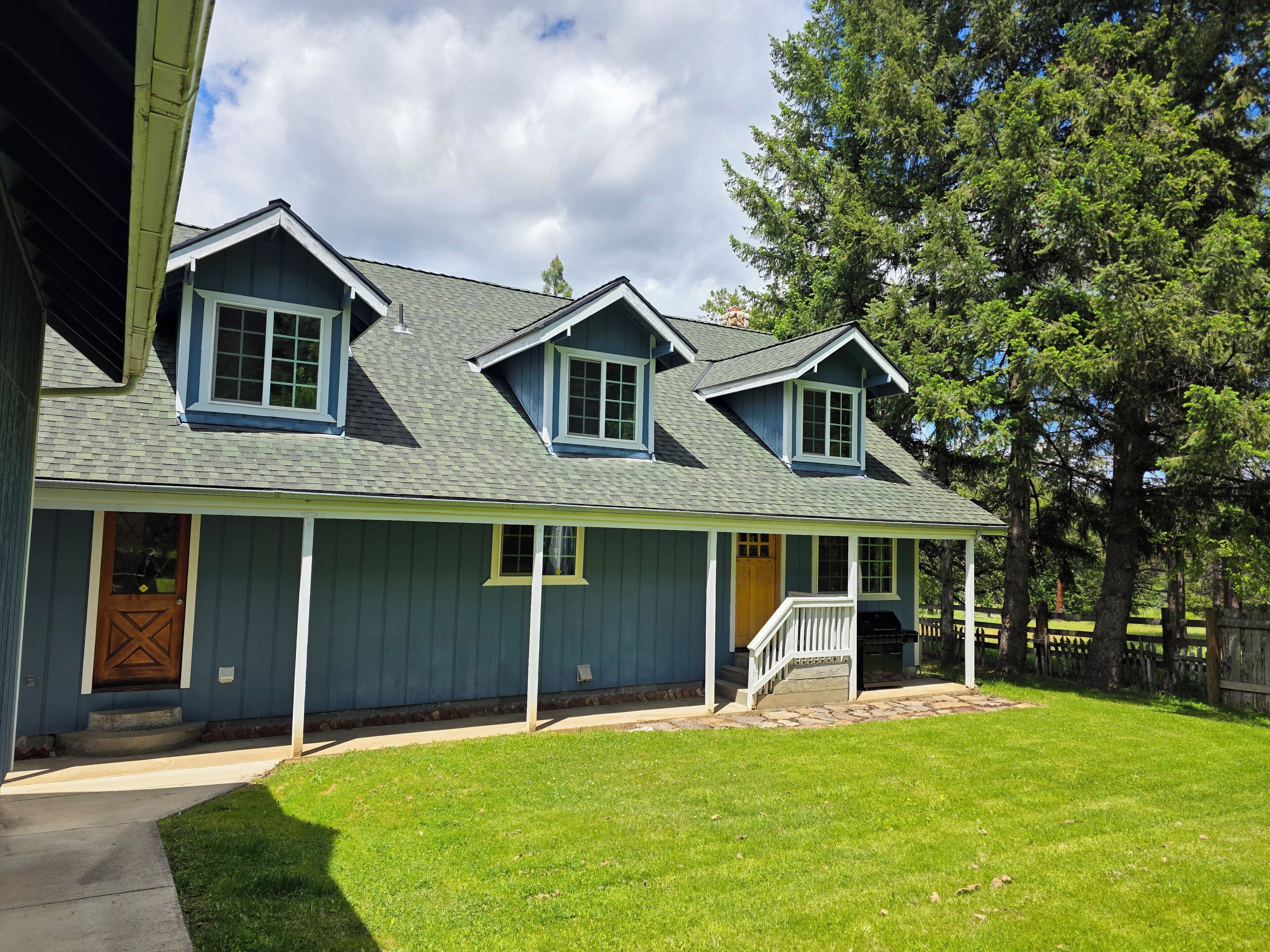 A two-story house with a front porch, a covered entryway, and a small deck.