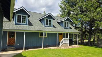 A two-story house with a front porch, a covered entryway, and a small deck.