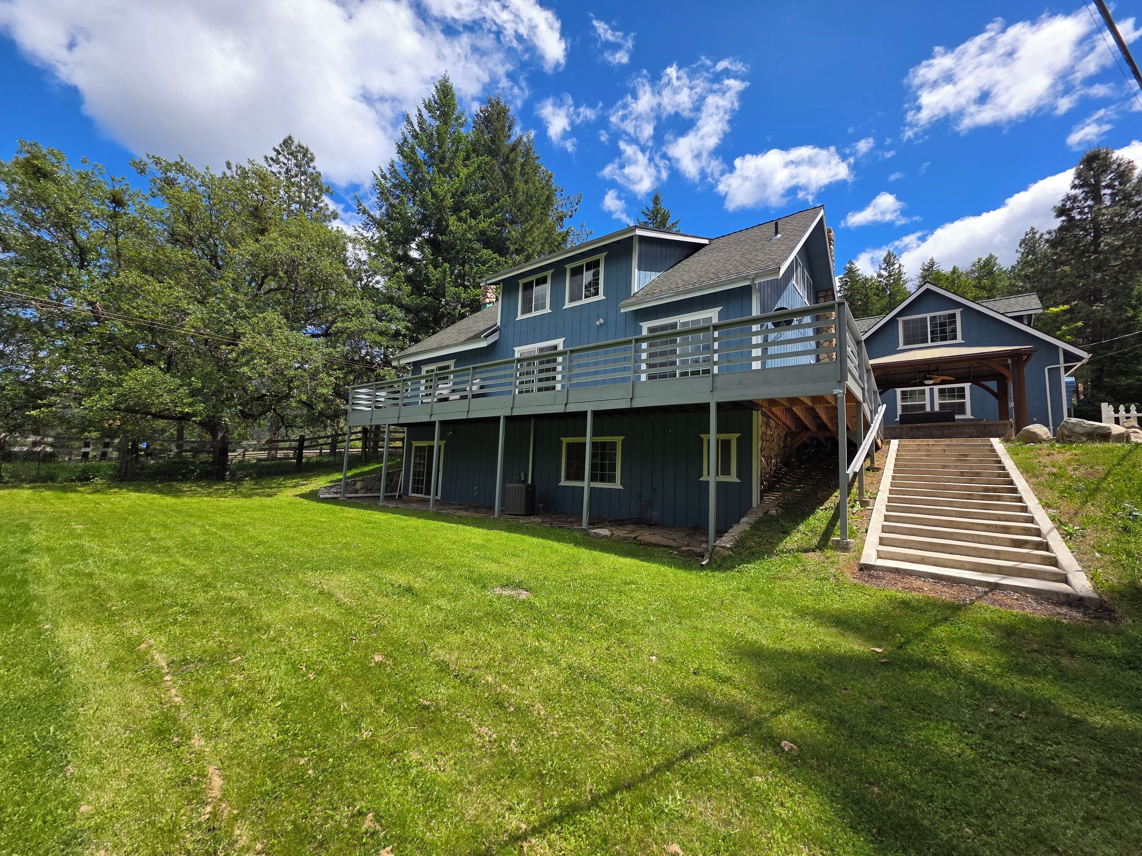 A two-story house with a covered porch and a staircase leading to a second level.