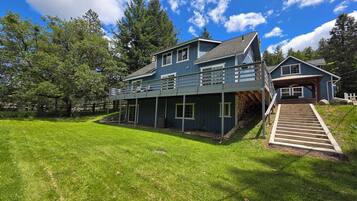 A two-story house with a covered porch and a staircase leading to a second level.
