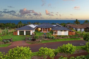 A modern house with a garage, a covered patio, and a view of the ocean.