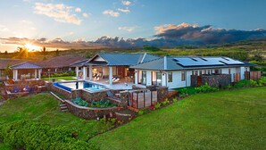 A modern house with a swimming pool, a covered patio, and a view of the surrounding landscape. - Kauai Oasis Luxe Ocean View, Pool SPA AC Sleep22 (Koloa)