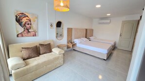 A modern hotel room with a beige sofa, a double bed, a small round table, and a wall-mounted mirror. - Loft Mr1-4g Facing the sea in a High Level Neighborhood (Cartagena)