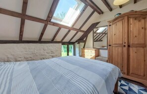 Cozy retreat with a sloped ceiling, large window, and comfortable bed.