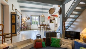 A spacious living area with a staircase, a dining table, and a television. - 3 bedroom awesome home in Saint-Denis-d'Oléron (Saint-Denis-d'Oléron)